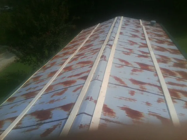 Rusted metal roof panels with new wood purlins before replacement — Storm Damage Roof Repair in Laketown by Roofing Brothers