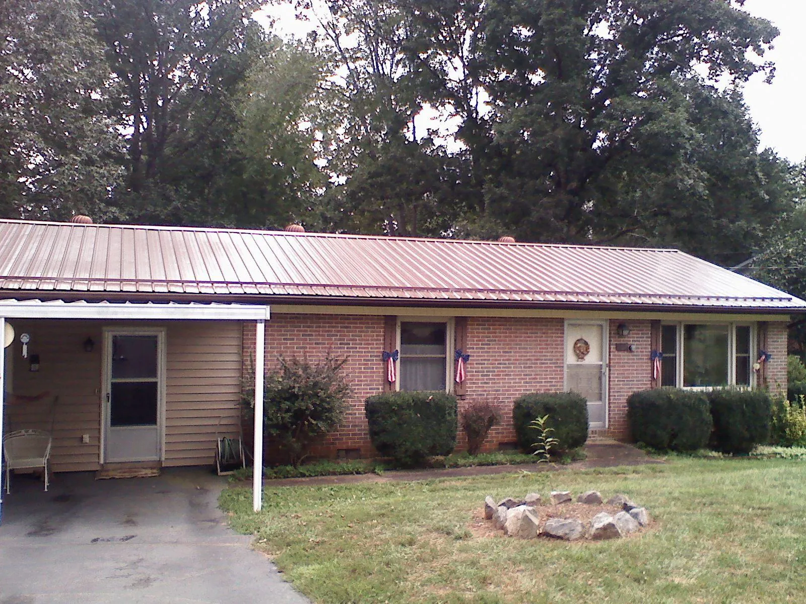 Bronze metal roof and carport on a brick ranch home — Roof Repair work by our crew in Laketown