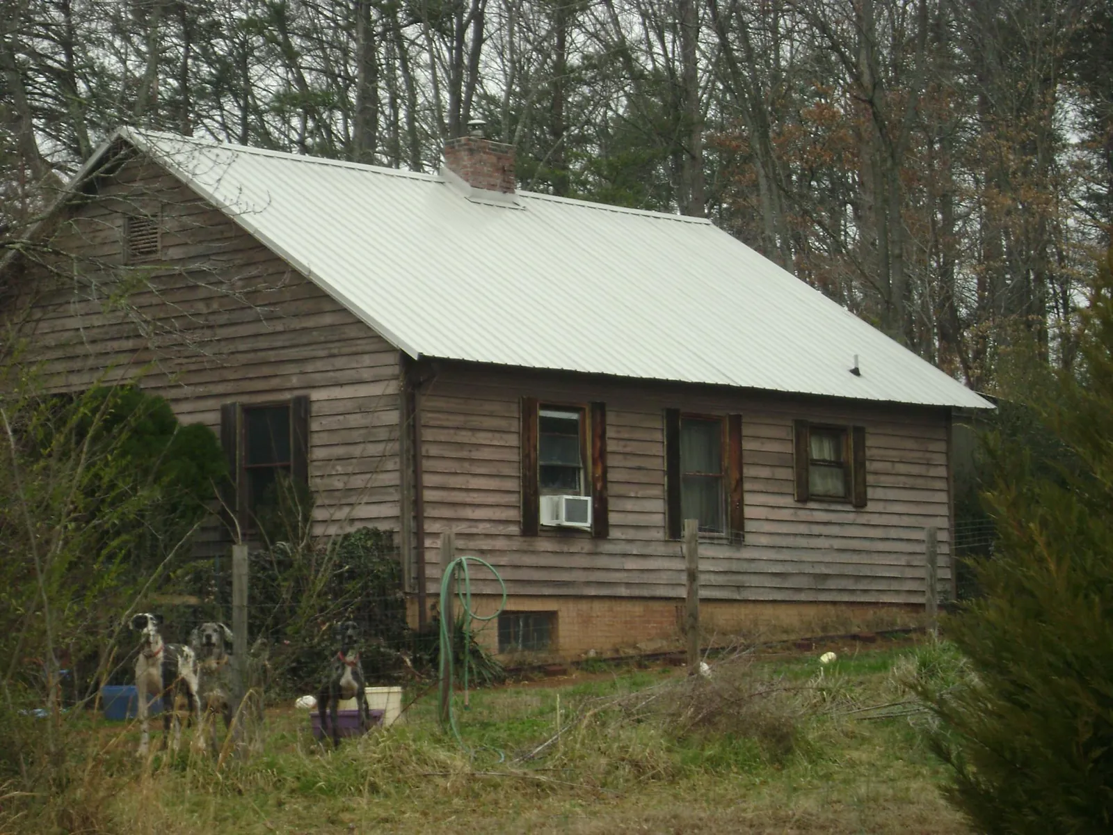 White metal roof on an old wood sided farmhouse, from a Metal Roof Installation job in Laketown